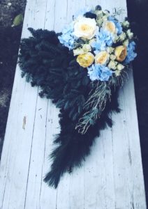 dekoracja na grób w kształcie serca z niebieskimi i żółtymi kwiatami